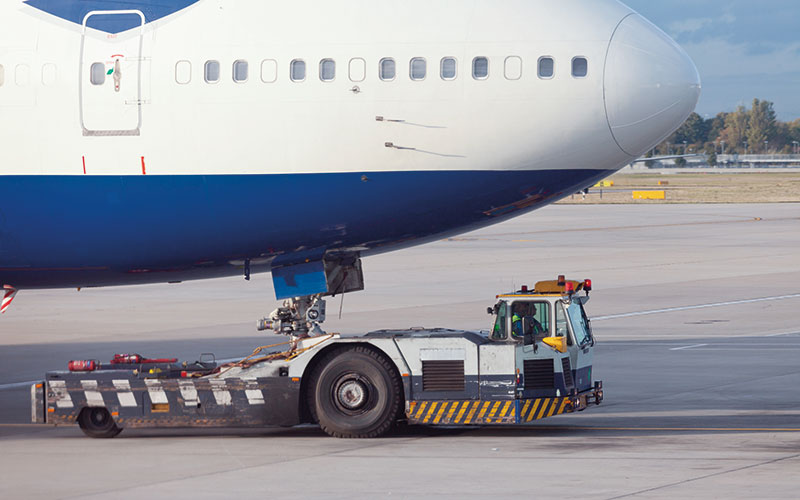 Lentokoneita kuljetetaan traktorilla maassa.